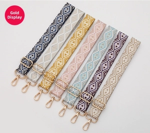 Close-up of geometric woven replacement straps with gold rotating metal buckles