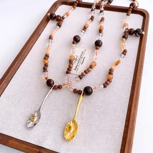 Collier vintage en perles de bois avec pendentif cuillère serti d'une pierre ambre