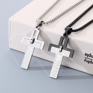 Detail of silver and black stainless steel cross pendants with engraved scripture text