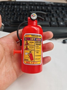 Close-up of red fire extinguisher squirt gun toy featuring English labels and gauge