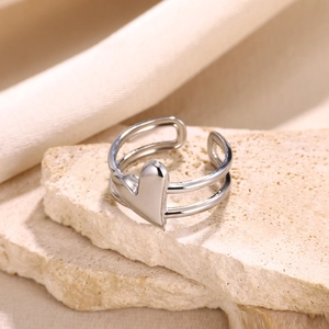 Detail of silver double-layered open ring featuring a polished 3D heart on stone base
