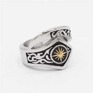 Macro detail of vintage steel ring showing gold star emblem and wave carvings