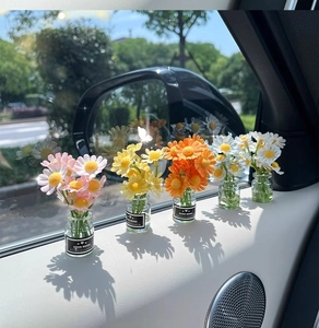 Miniature glass daisy vases with Good Mood label on car interior door handle