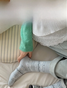 Close-up of light blue knit crew socks with cute white rabbit pattern and wave textures