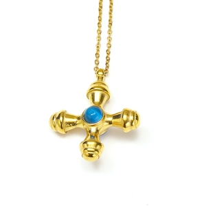 Macro detail of a vintage 18k gold-plated cross pendant featuring a blue gemstone center