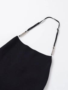 Close-up of black knitted top featuring adjustable thin straps with silver metal beads