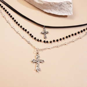 Detailed close-up of dark gothic triple-layer necklace featuring silver crosses and black beads