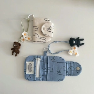 Detail of floral canvas coin purses in blue and beige with cute knit bear charms