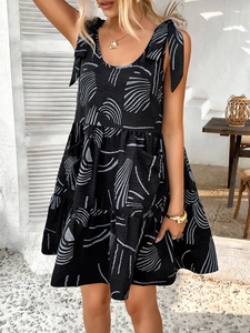 Detail of black sundress with white abstract lines and shoulder tie straps on the patio