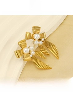 Detailed view of gold stainless steel bow earrings with multi-size pearl embellishments