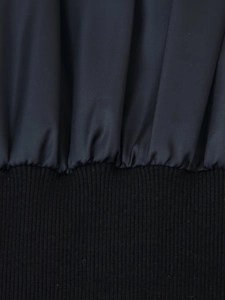 Detail of grey twill fabric and black ribbed knit cuff stitching on winter jacket