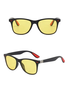 Close-up of classic black matte sunglasses with yellow night vision lenses and red accents
