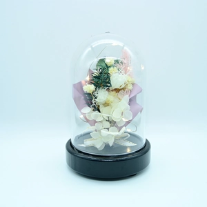Detail of preserved roses in glass dome with LED lights and black wooden base