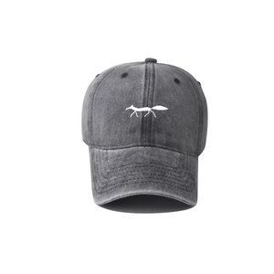 Detailed view of white fox embroidery on washed charcoal grey cotton baseball cap
