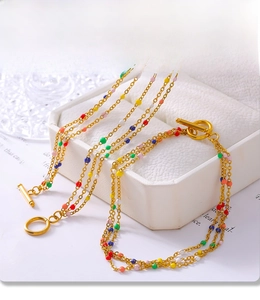 Detail of PVD gold plated necklace set featuring colorful enamel beads and toggle clasp