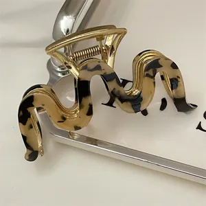 Close-up of golden wavy hair claw clip with elegant amber tortoiseshell texture