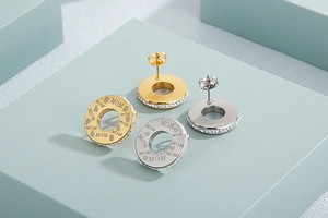 Detailed view of gold and silver MOM stud earrings with sparkling side zircon accents