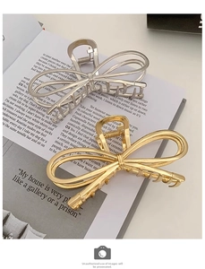 Close-up of elegant gold and silver metal bow hair claws on a book for a chic look