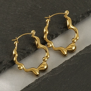 Vue détaillée des boucles d'oreilles créoles vagues en acier doré 18 carats