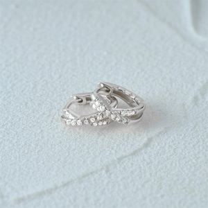 Macro shot of silver double-layered cross earrings with sparkling pavé cubic zirconia