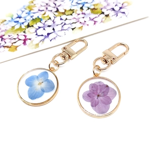 Forget-me-not dried flower keychains in blue and purple resin with golden frames