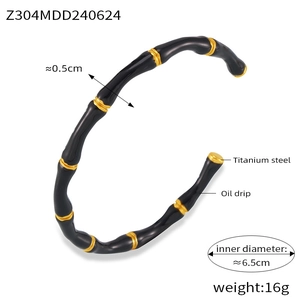 Macro detail of bamboo design titanium steel bangle with black enamel and gold finish