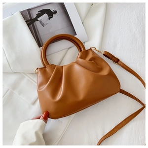 Detail of camel cloud bag featuring pleated texture and round wooden handle with gold hardware