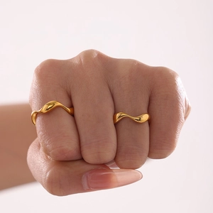 Minimalist gold wave curved ring for women with polished irregular metallic finish