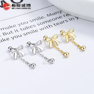 Macro shot of 925 silver butterfly earrings with long tassels in gold and silver