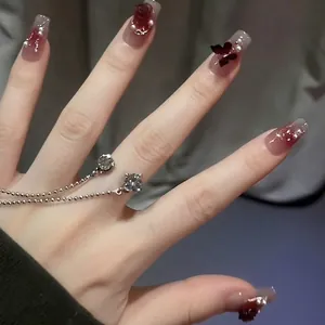 Faux ongles faits main dégradé rouge avec rose 3D, perles et bague à pompon