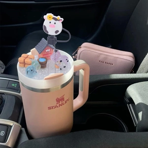 Pink tumbler lid detail featuring farm miniature decorations and cow straw cover accessory