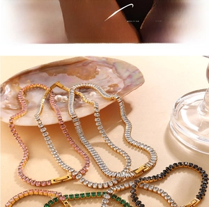 Gros plan de colliers tennis avec zircons colorés posés sur coquillages et perles