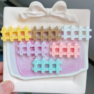 Macro shot of six colorful glossy mini resin fence accessories on a ceramic plate