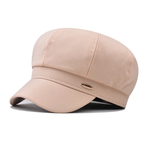 Close-up of khaki octagonal newsboy cap showing cotton texture and gold metal tag