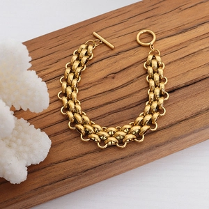 Golden chunky chain bracelet with T-bar toggle clasp on wood and coral display