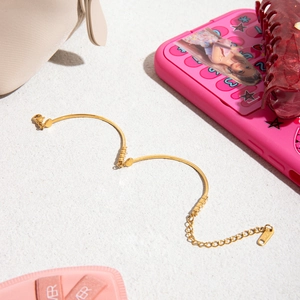 Detail of 18K gold stainless steel snake chain bracelet with a round tag charm