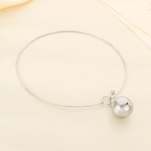Vue macro d'un collier en acier inoxydable argenté avec un pendentif sphère lisse