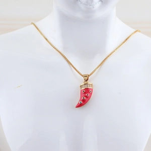 Detail of gold necklace with red horn pendant and micro zircons on a white bust