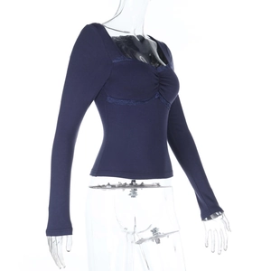 Gros plan sur un haut en maille bleu marine ajusté avec dentelle délicate et texture côtelée