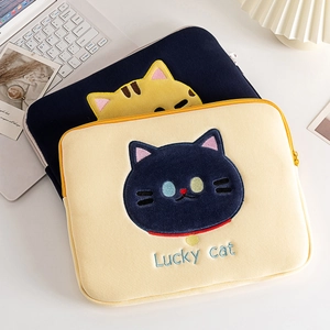 Close-up of cute lucky cat embroidery on plush laptop sleeve with soft texture