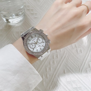 Macro view of women quartz watch with silver rhinestone bezel and white silicone strap