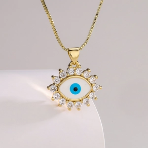 Gold plated evil eye necklace with blue zircon pendant on a minimalist display