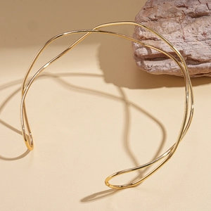 Minimalist gold geometric choker featuring twisted double lines on a neutral background