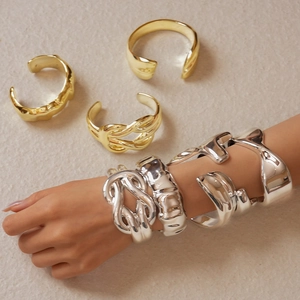 Detailed macro view showing the textured molten fluid design and polished gold bangle finish