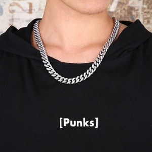 Close-up of a silver iced-out Cuban link chain necklace with sparkling crystals on a model