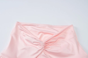 Detail view of the pink soft fabric showing the intricate twist knot design and texture