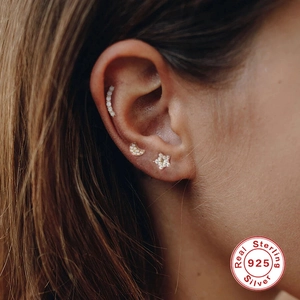 Macro detail of S925 sterling silver gold earrings featuring moon, star and diamond studs