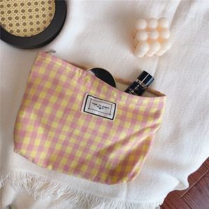 Pink and yellow checkered cotton makeup bag with Time to Party label on a cozy blanket