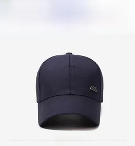 Front view of a dark blue cotton baseball cap with a refined silver metal logo emblem