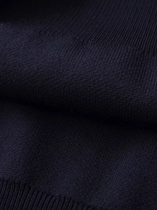 Macro detail of navy blue striped knit polo shirt fabric with fine ribbed texture